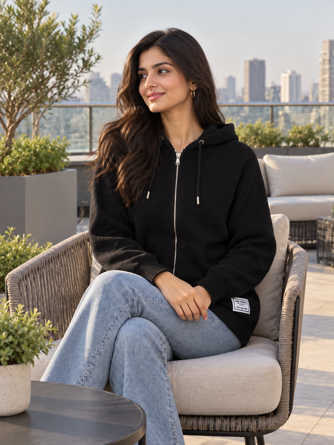 Woman wearing black knit zip-up hoodie by Purple Imli in a city street look
