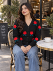 Woman wearing black 3D flower V-neck cardigan by Purple Imli in a city street look