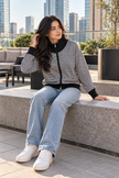 Woman wearing black fine stripe zip-up cardigan by Purple Imli in a city street look