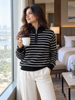 Woman wearing black breton stripe half-zip sweater by Purple Imli in a city street look