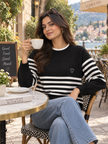 Woman wearing black striped raglan sweater by Purple Imli in a city street look