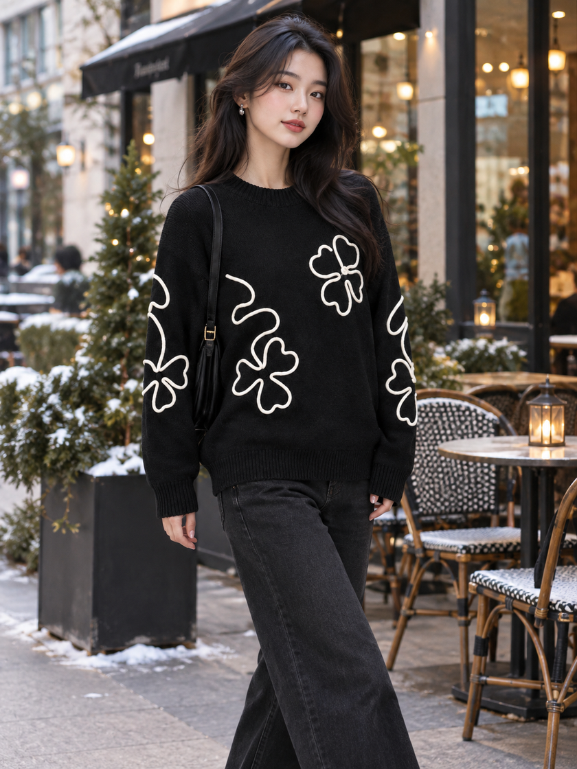 Woman wearing black outline flower sweater by Purple Imli in a city street look