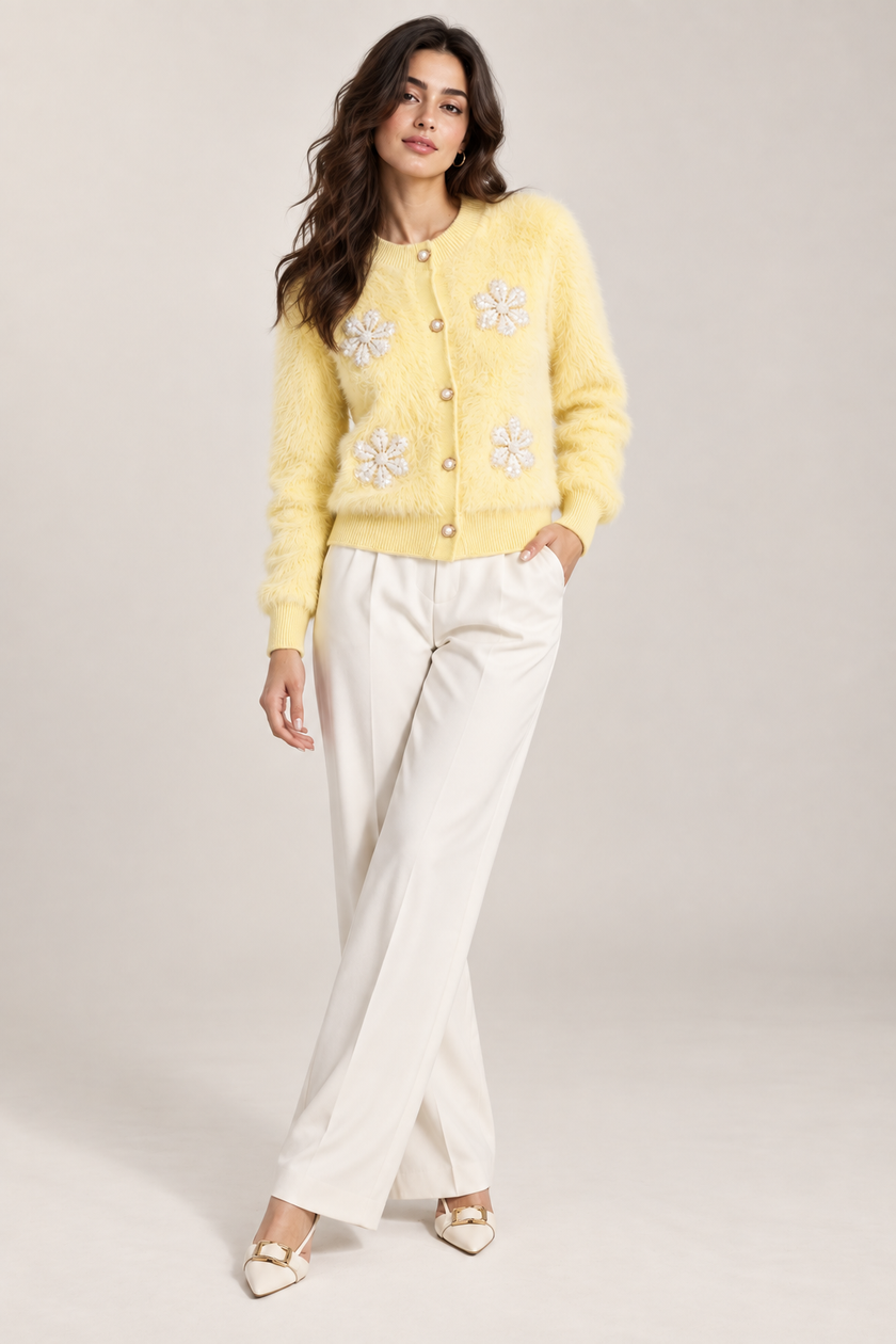 Woman wearing light yellow fuzzy pearl flower cardigan by Purple Imli in a city street look
