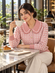 Woman wearing pink houndtooth ruffle collar cardigan by Purple Imli in a city street look