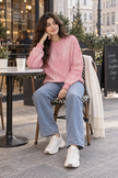 Woman wearing pink brushstroke rhinestone sweater by Purple Imli in a city street look
