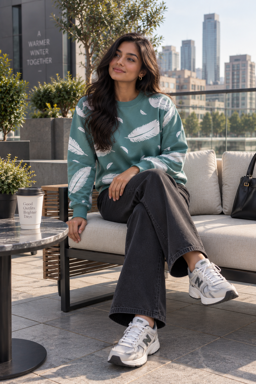 Woman wearing teal green feather print sweater by Purple Imli in a city street look