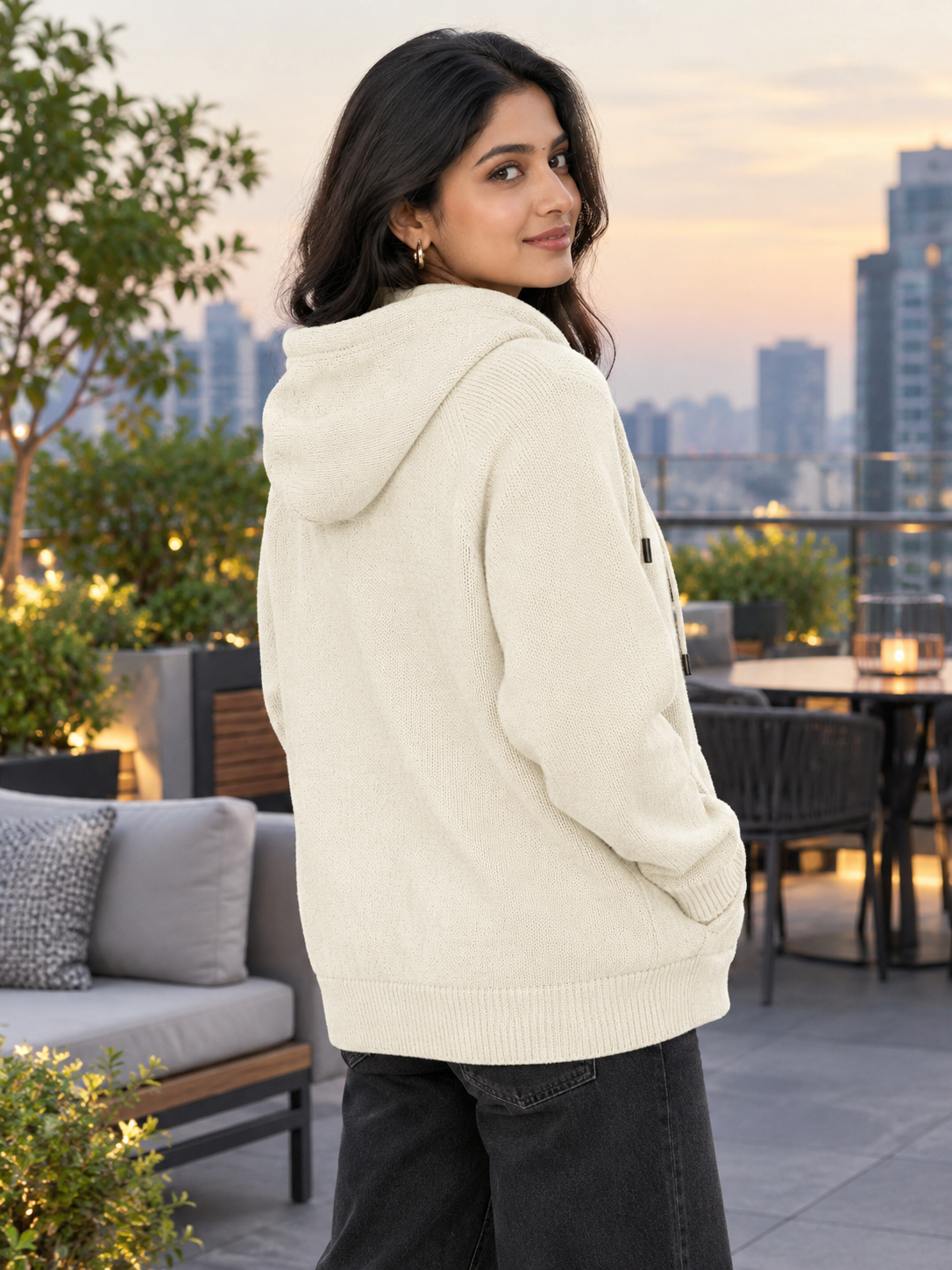 Woman wearing white knit zip-up hoodie by Purple Imli in a city street look