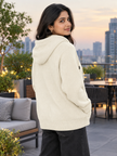 Woman wearing white knit zip-up hoodie by Purple Imli in a city street look